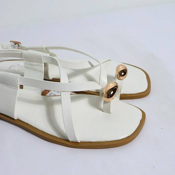 Sandalias planas color blanco, detalle del broche dorado